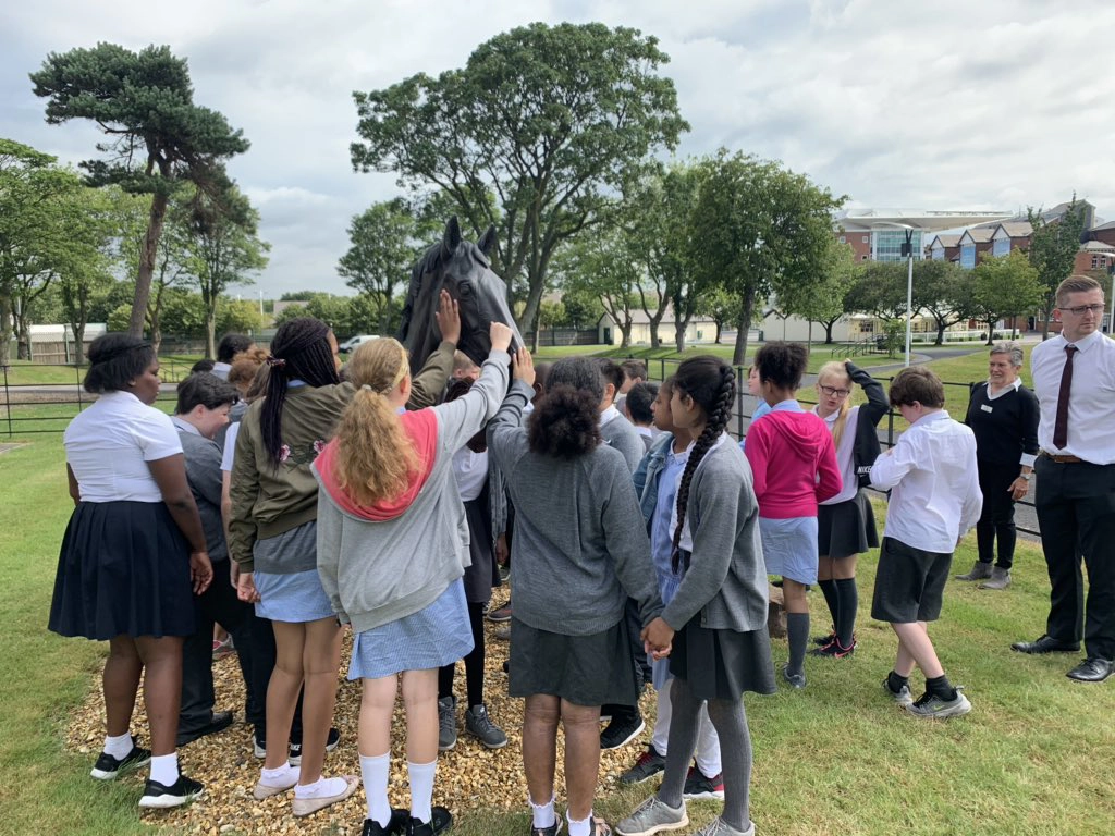 A group of school children at Aintree Racecourse during a tour